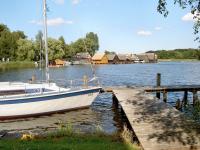 Mecklenburgische Seenplatte Bootscharter Mueritz Segelyacht am Steg Bootshaeuser